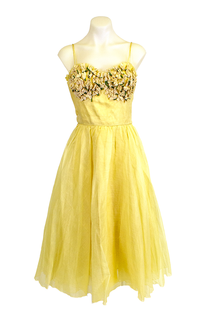 A knee-length bright yellow dress with shoulder straps, fabric detailing on the top, and a flair skirt