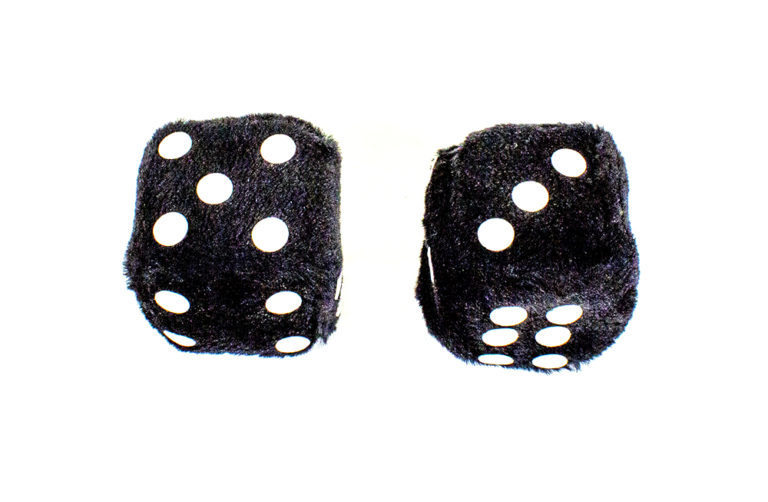 Two black fluffy dice with white spots showing numbers five and three.