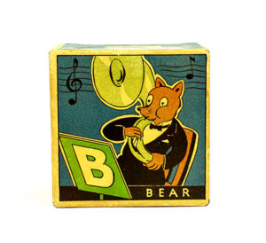 Each block is square and has illustrated decorations. There is one block for each note of the musical scale, C D E F G A B C. The blocks are hollow and have bells inside. The B block has an illustration of a bear playing a tuba and the sides have illustrations of the musical scale.